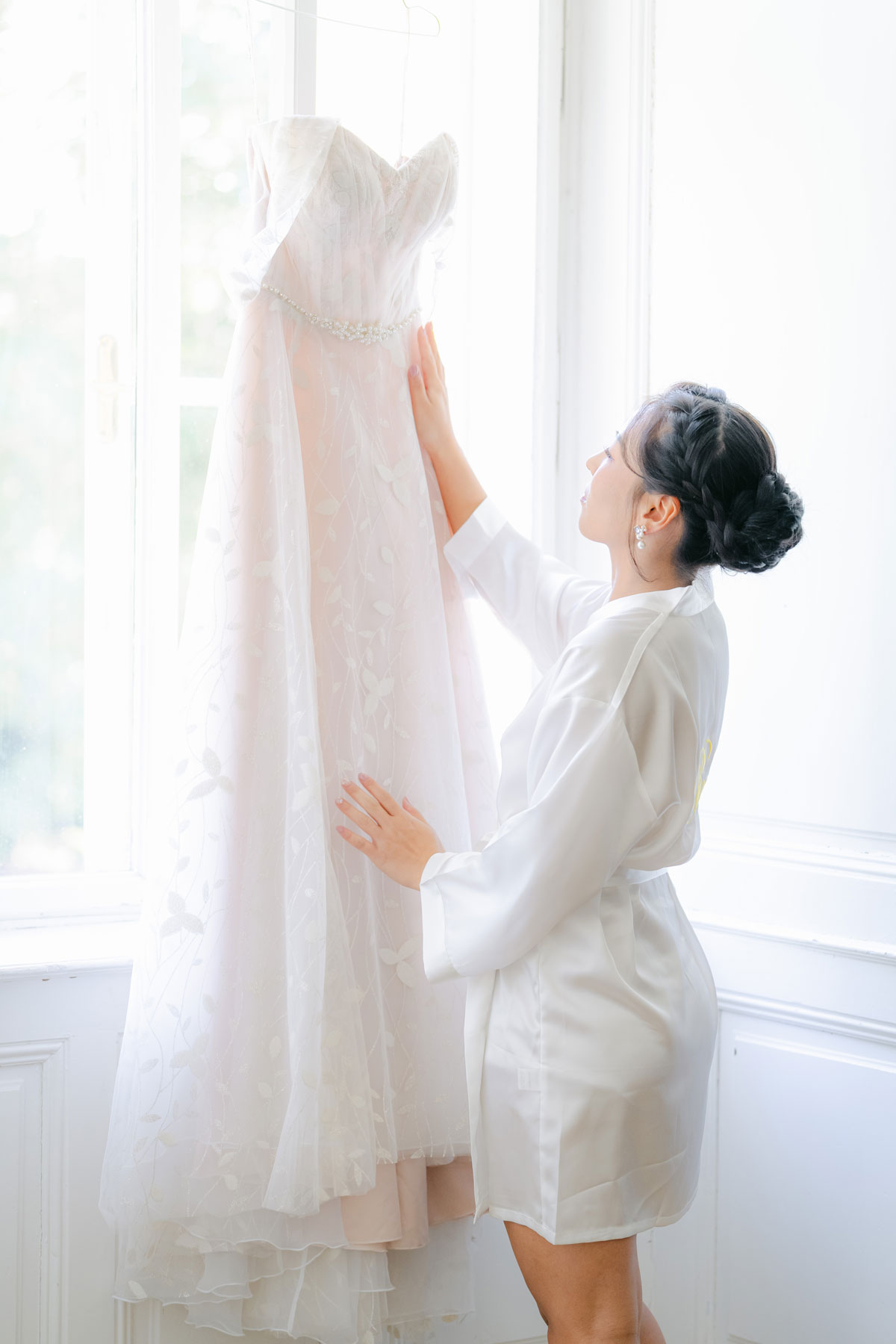 Braut beim Getting Ready mit Blick auf ihr Brautkleid – fotografiert von diehochzeitsfotografen.at, Vienna Wedding Photography and Videography
