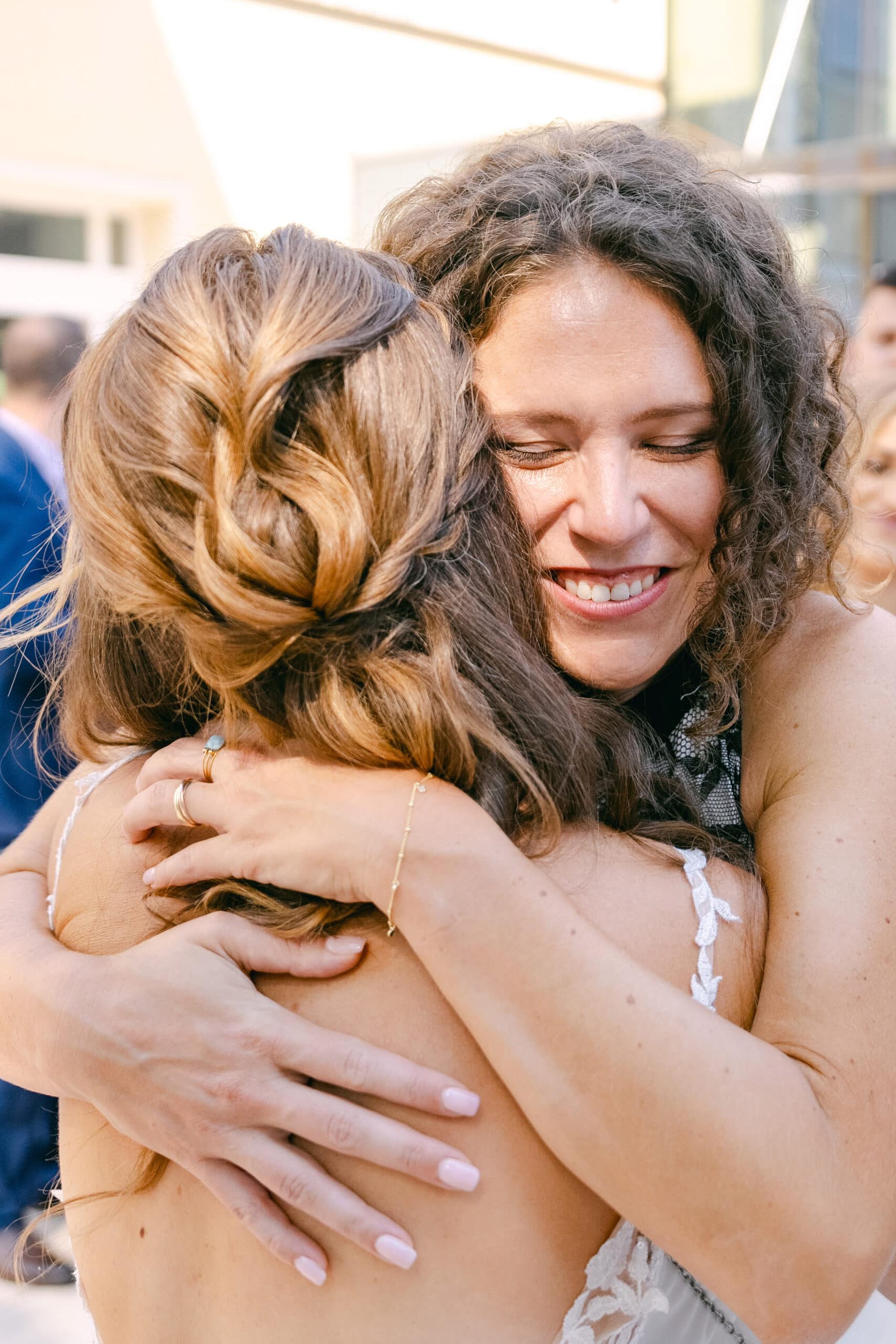 Emotionale Umarmung der Braut mit einer Freundin bei der Hochzeit im Schloss Vasoldsberg
