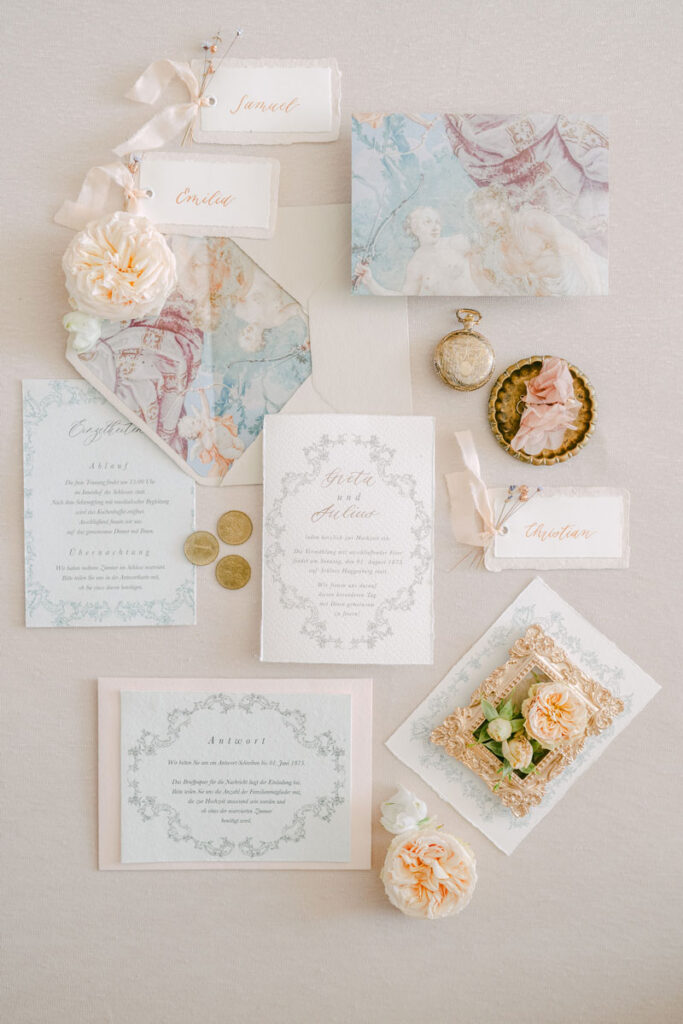 Detailaufnahme einer künstlerischen Hochzeitseinladung mit antikem Design und Goldmünzen