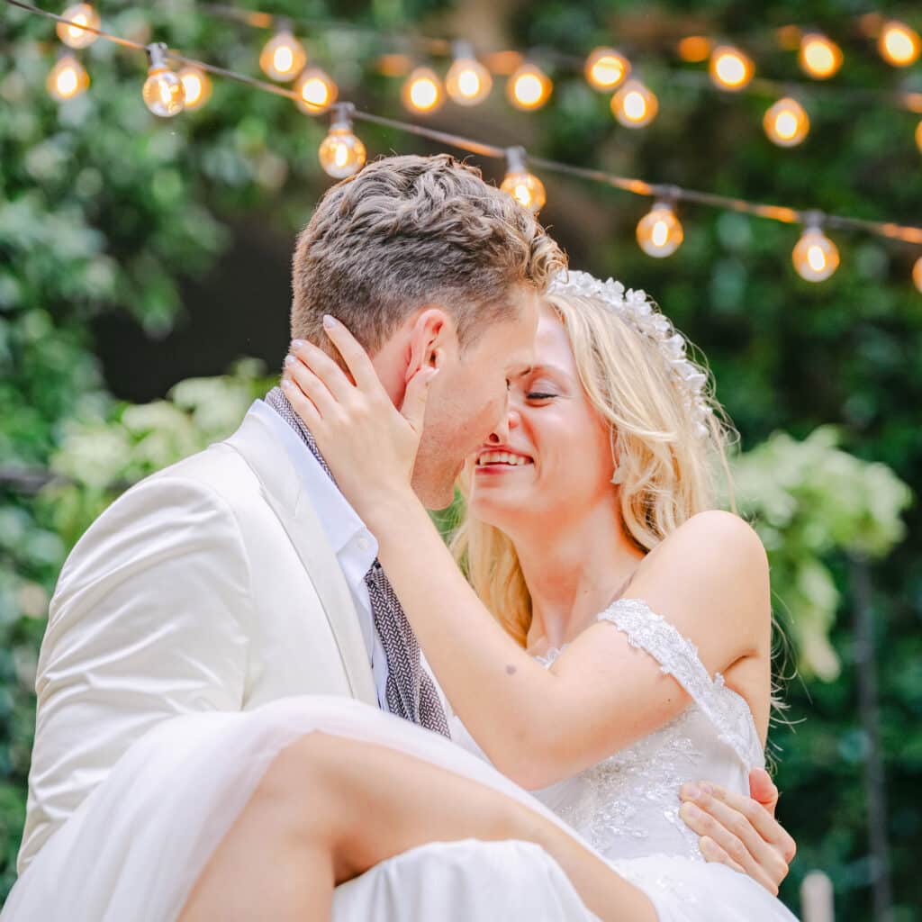 Emotionaler Moment bei einer Destination Wedding im Schloss Rubein in Meran – das Brautpaar in inniger Umarmung, umgeben von Lichterketten