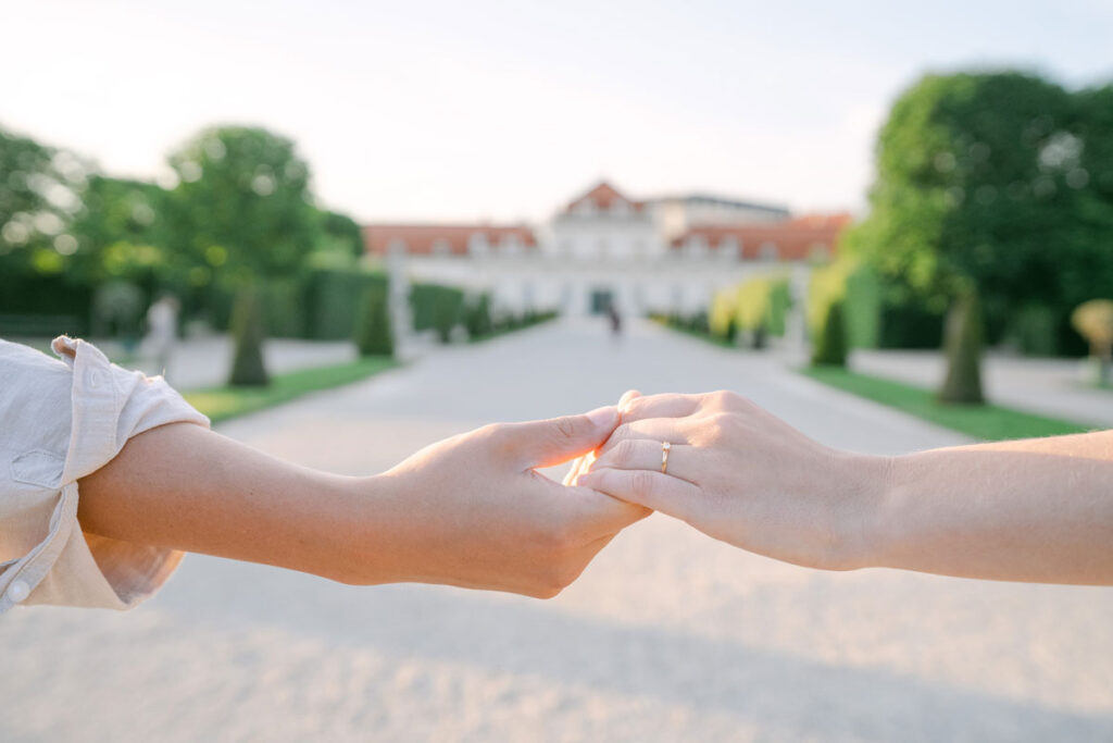 Verlobungsshooting im Schloss Belvedere Wien – Detailaufnahme von Viki & Manuel, wie sie sich zärtlich an den Händen halten