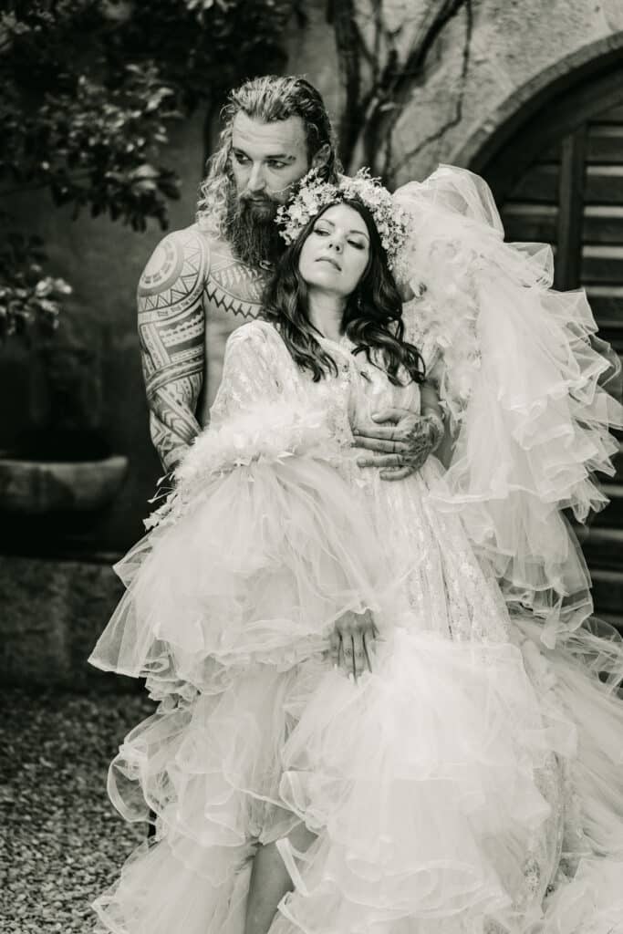 Brautpaar bei exklusiver Hochzeit in Schloss Rubein in Meran – Schwarzweißaufnahme im romantischen Innenhof