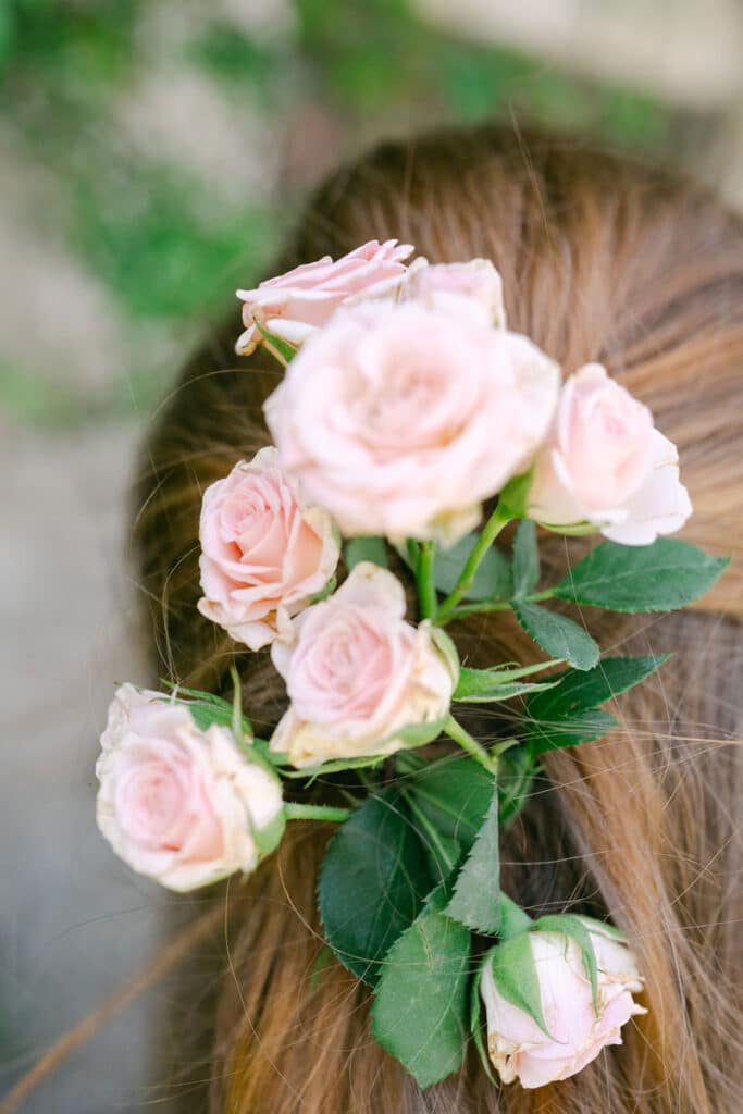 Zarte rosa Rosen als floraler Haarschmuck in einer Brautfrisur